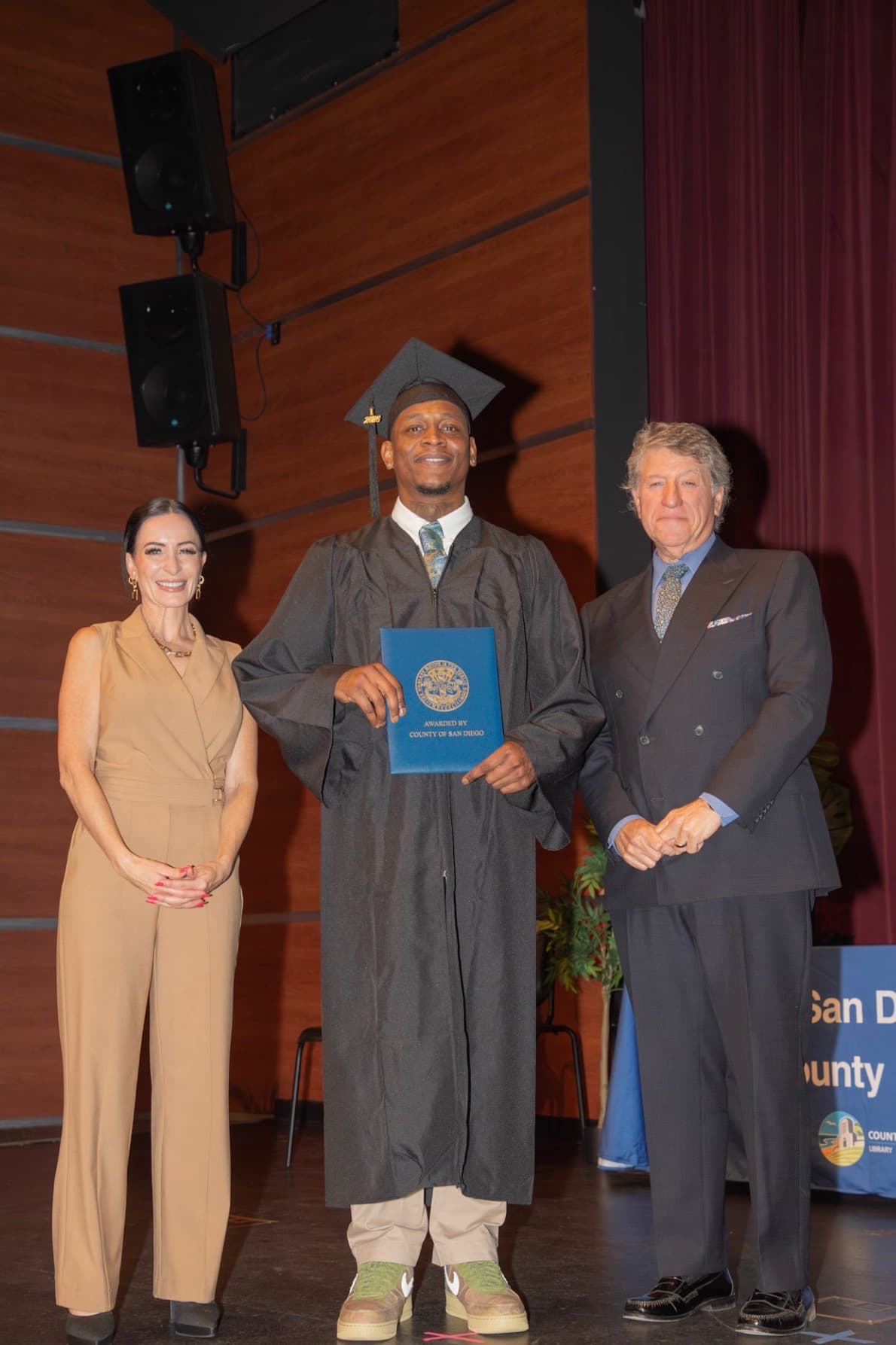 Coastal Pathways participant celebrating his graduation on stage